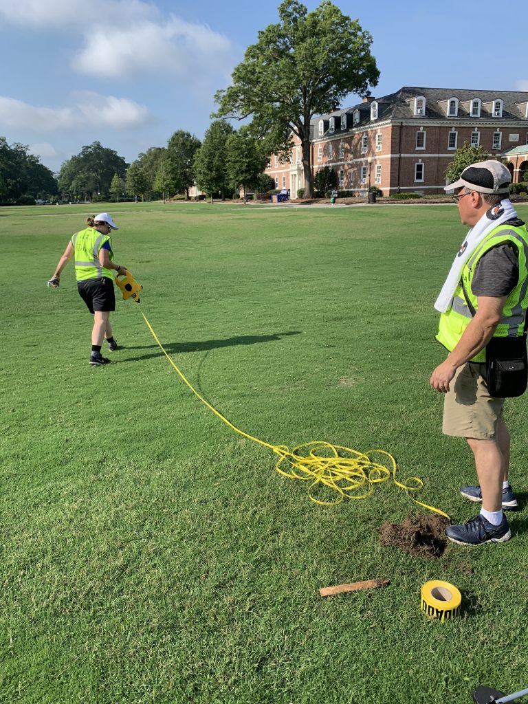 Megan Mendenhall, left, and Bill Snead, right, use a measuring tape to mark the outline of the class photo.  This year, the temperatures were in the high 90s, so our team took frequent breaks and drank plenty of water.