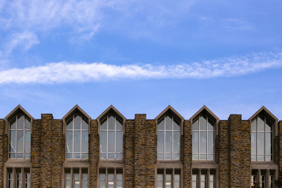 The windows of Perkins Library are framed against an evening sky.