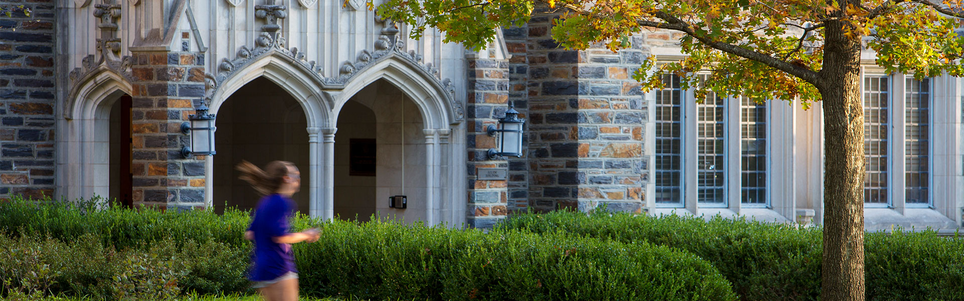 A header image of someone jogging past the entrance to the Allen Building on Duke’s West Campus in the fall